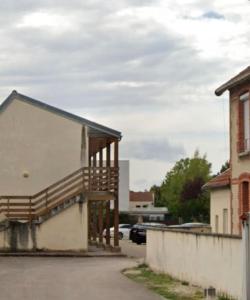 un bâtiment avec un escalier en bois dans un parking dans l'établissement Chez k - Studio - Proche Centre - Parking, à Sainte-Savine