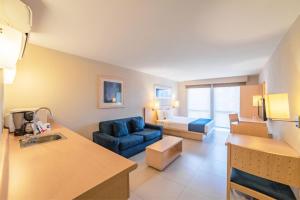 Habitación de hotel con cama y silla azul en City Express by Marriott Villahermosa, en Villahermosa