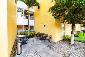 a patio with a table and chairs next to a building at City Express by Marriott Villahermosa in Villahermosa