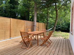 a wooden table and chairs on a wooden deck at Le Rivera - Clim - Parking - Netflix - Nestor & Margot in Auterive