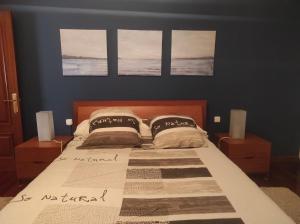 a bedroom with a bed with two pillows on it at As pitas in Tapia de Casariego