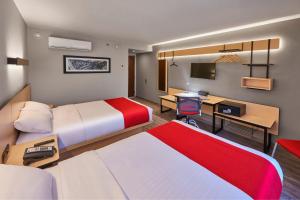 a hotel room with two beds and a desk at City Express Plus by Marriott Periferico Sur Tlalpan in Mexico City