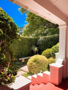 Cape Town的住宿－5營街旅館及自助公寓，花园,有红色的台阶和灌木