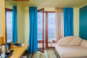 a bedroom with a bed and a desk and a window at Mirage Hotel in Nesebar