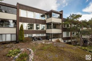 un edificio de apartamentos con jardín frente a él en Westend Luxury Spa House en Espoo