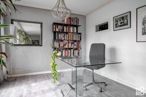 a glass table in a room with a book shelf at Westend Luxury Spa House in Espoo