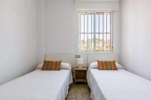 2 camas en una habitación con ventana en A&N Torreon del Carmen, en Algarrobo Costa