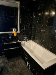 een badkamer met een wit bad en een wastafel bij Exclusive Suite Parisian Palace in Parijs