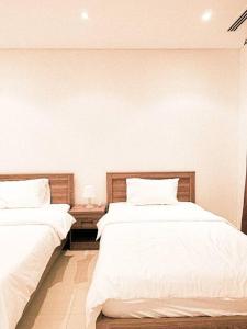 dos camas sentadas una al lado de la otra en un dormitorio en Woody Flat, en Seeb