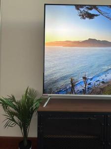una pantalla de televisión con una foto del océano en Woody Flat, en Seeb