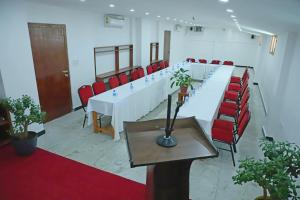 a long table in a room with red chairs at The BD Hotel in Thimphu