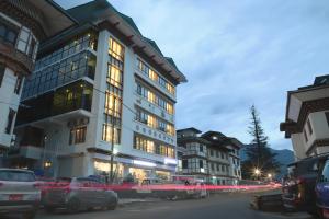a tall building with cars parked in front of it at The BD Hotel in Thimphu +16 photos