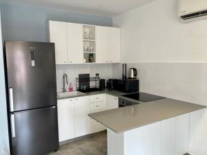 a kitchen with white cabinets and a stainless steel refrigerator at Charming Kosher Private Duplex, Prime City Center, Steps to Machane Yehuda in Jerusalem