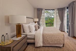 a bedroom with a bed and a large window at The Alfred - Digana in Digana