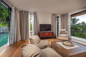 a living room with a couch and a tv at The Alfred - Digana in Digana