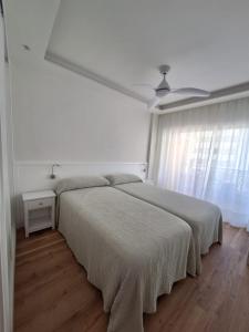 um quarto branco com 2 camas e uma janela em SEAFRONT APARTMENT em Marbella