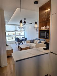 uma cozinha e sala de estar com um sofá e uma mesa em SEAFRONT APARTMENT em Marbella