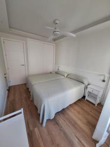 um quarto com uma cama e uma ventoinha de tecto em SEAFRONT APARTMENT em Marbella