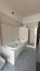 biała łazienka z wanną i toaletą w obiekcie Attico con Vista su Genova w Genui