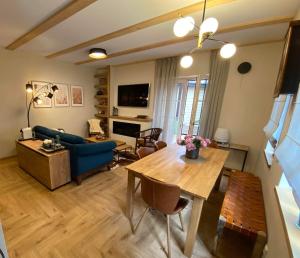 a living room with a table and a blue couch at Memel Townhouse apartamentai in Klaipėda