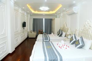 um quarto de hotel com três camas com bengalas de doce em Noi Bai Ville Airport Hotel em Hanói