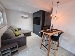 een woonkamer met een bank en een tafel bij Apartment Luce in Lovran