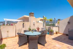 a patio with a table and chairs on a balcony at Penthouse Mirador 5B Casasol in Nerja