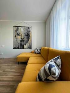 a living room with a yellow couch and a window at Apartment Jõesuu in Narva