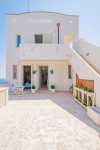 Casa blanca con escalera y patio en FinisTerrae Rooms and Suites, en Gagliano del Capo