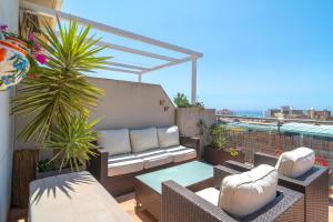 d'une terrasse avec un canapé et une table sur un balcon. dans l'établissement Penthouse Mirador 5B Casasol, à Nerja