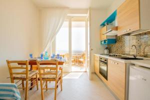 a kitchen and dining room with a table and chairs at FinisTerrae Rooms and Suites in Gagliano del Capo