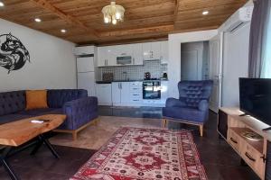ein Wohnzimmer mit einem Sofa, Stühlen und einem Tisch in der Unterkunft Yıldız in Fethiye