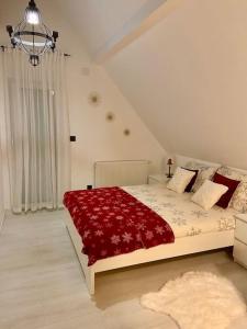 una camera da letto con un grande letto con una coperta rossa di Farmhouse Dženi a Vlasic