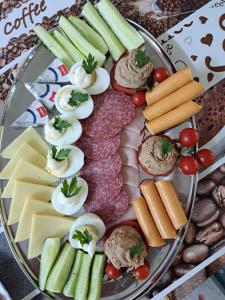 een bord met kaas, vlees en groenten bij Casa Gabi in Corbu