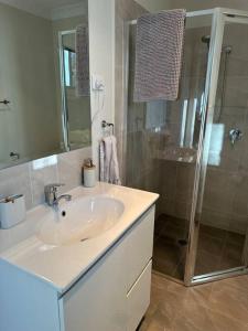 a bathroom with a sink and a shower at Gullivers Guest House in East Maitland