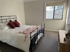 a bedroom with a large bed with a window at Gullivers Guest House in East Maitland