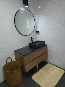 a bathroom with a sink and a mirror and a basket at Lost Paradise 1 in Hinkong