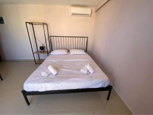 a bed with two pillows on it in a room at Lavrio 1Bdr penthouse 7 min on foot from the port in Lavrio