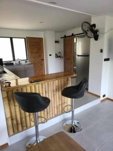 una cocina con dos taburetes negros frente a un mostrador en Lost Paradise 1, en Hinkong