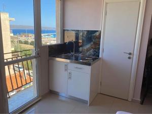 a kitchen with a sink and a balcony with a view at Lavrio 1Bdr penthouse 7 min on foot from the port in Lavrio