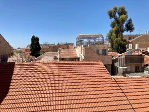 ein orangefarbenes Kacheldach einer Stadt mit Gebäuden in der Unterkunft Lovely New Private Duplex in Prime City Center location in Jerusalem