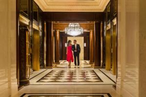 un hombre y una mujer caminando por un pasillo en un edificio en JW Marriott Essex House New York, en Nueva York