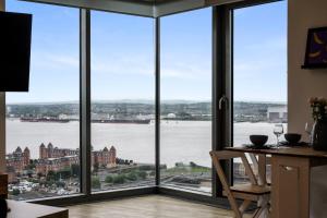 Habitación con ventanas grandes con vistas al agua. en Host & Stay - The Baltic Hideaway, en Liverpool