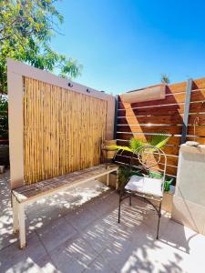 un banc assis à côté d'une clôture en bois dans l'établissement Eilat charming & cozy Studio, à Eilat