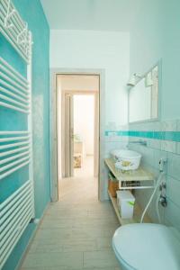 Baño azul con aseo y lavamanos en FinisTerrae Rooms and Suites, en Gagliano del Capo