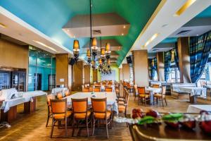 una sala da pranzo con tavoli e sedie bianchi di Mirage Hotel a Nesebar