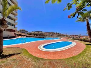 a large swimming pool next to a building at Apartment Amaro, El Palm Mar, Tenerife in Palm-Mar
