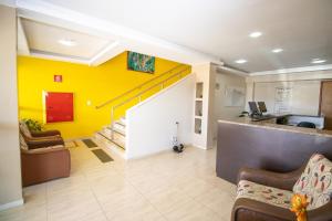 un vestíbulo con una pared amarilla y una escalera en Alvimar Hotel, en Sobradinho