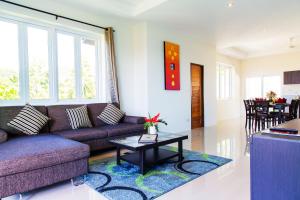 ein Wohnzimmer mit Sofa und Tisch in der Unterkunft TROPICA - Villas Resort in Bophut 