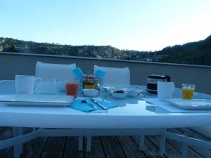 - une table blanche avec un ordinateur portable sur un balcon dans l'établissement La Désirade, à Salles-la-Source